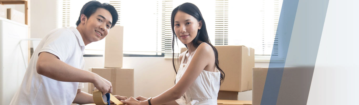 Asian couple packing boxes in home