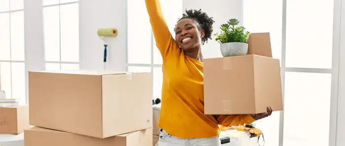 Woman cheering as she enters new home with boxes