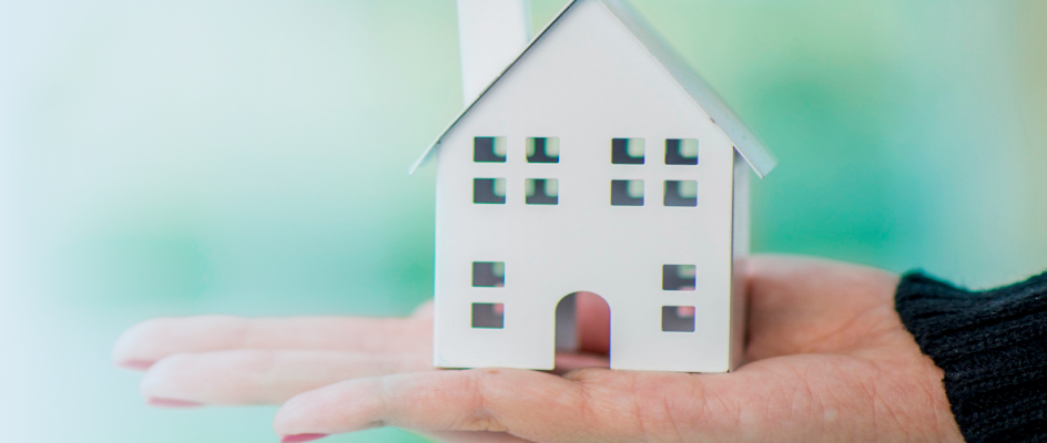 hand holding a toy house.