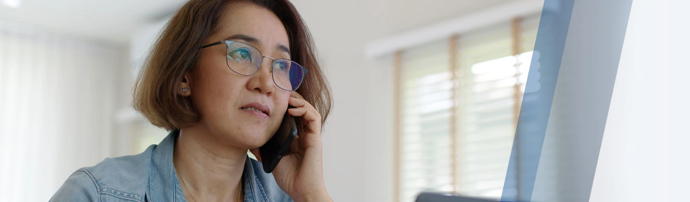 woman on cellphone in front of laptop