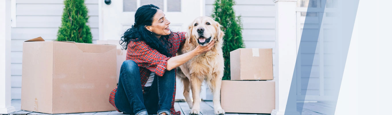 woman with dog on a porch with boxes.